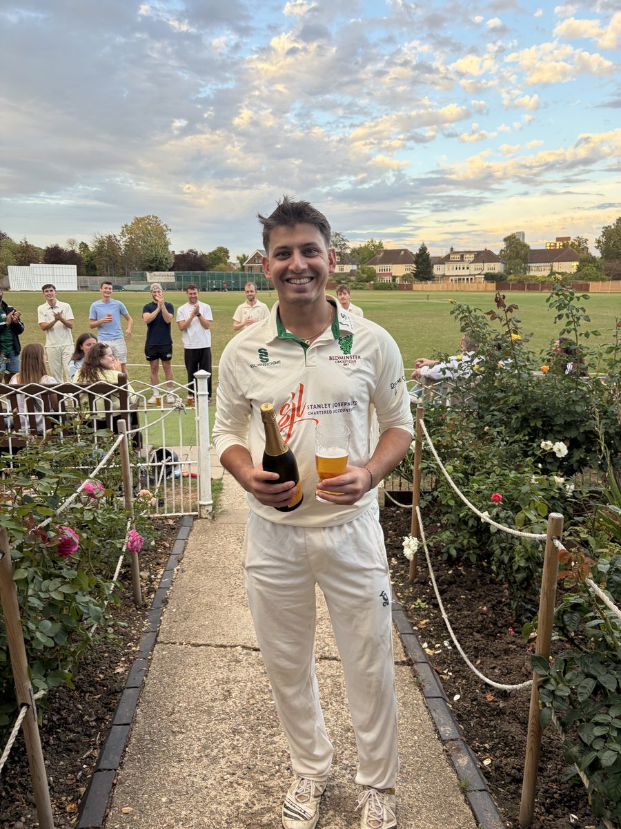 Player celebrating with champagne on the pathway to the pavilion